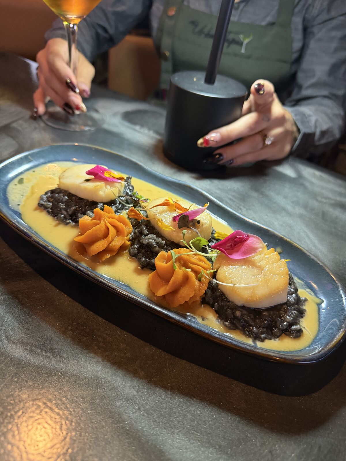 Seared scallops over squid ink risotto